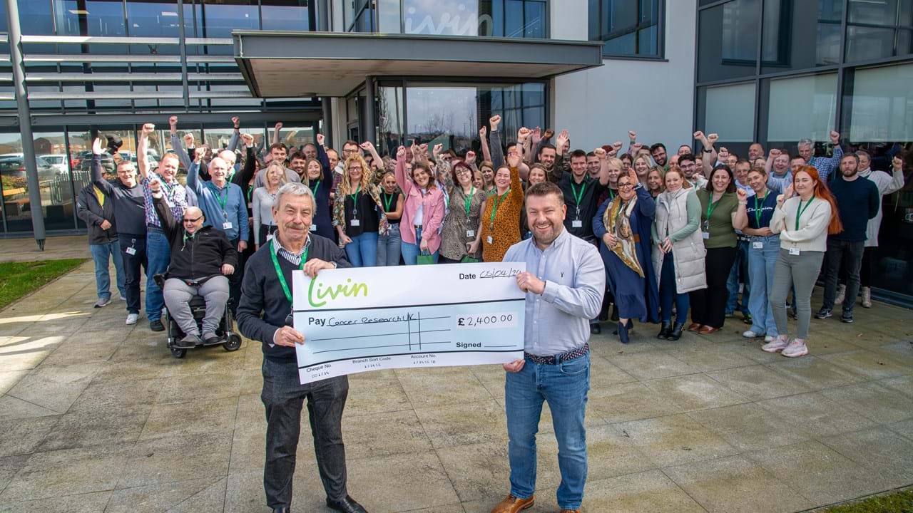 Chief Executive and Chair of the Board holding a cheque for money raised