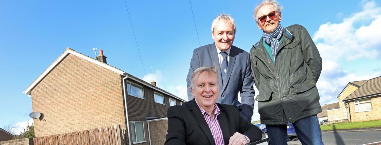 A group including Colin Steel (Chief Executive Officer) and Alan Fletcher (Chair of the Board) stood in front of the St. Davids Close sign.