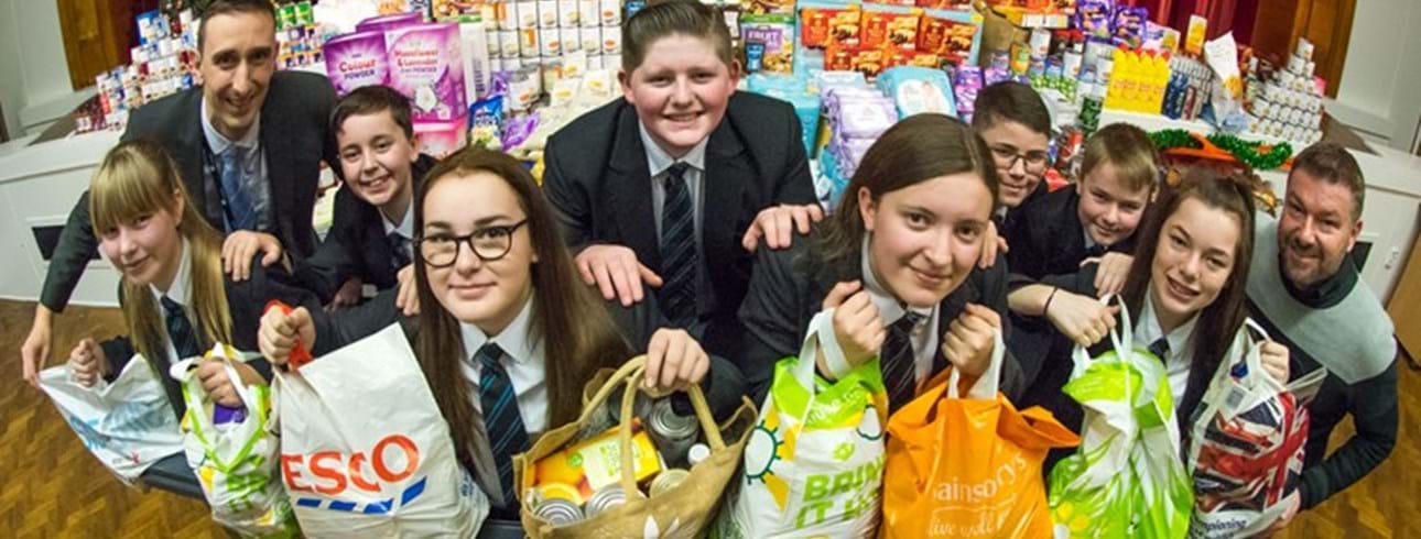 Alan Boddy (Executive Director Housing and Operations) with the students of Whitworth Park School and their foodbank donations.
