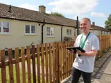 A home condition surveyor outside one of our bungalows
