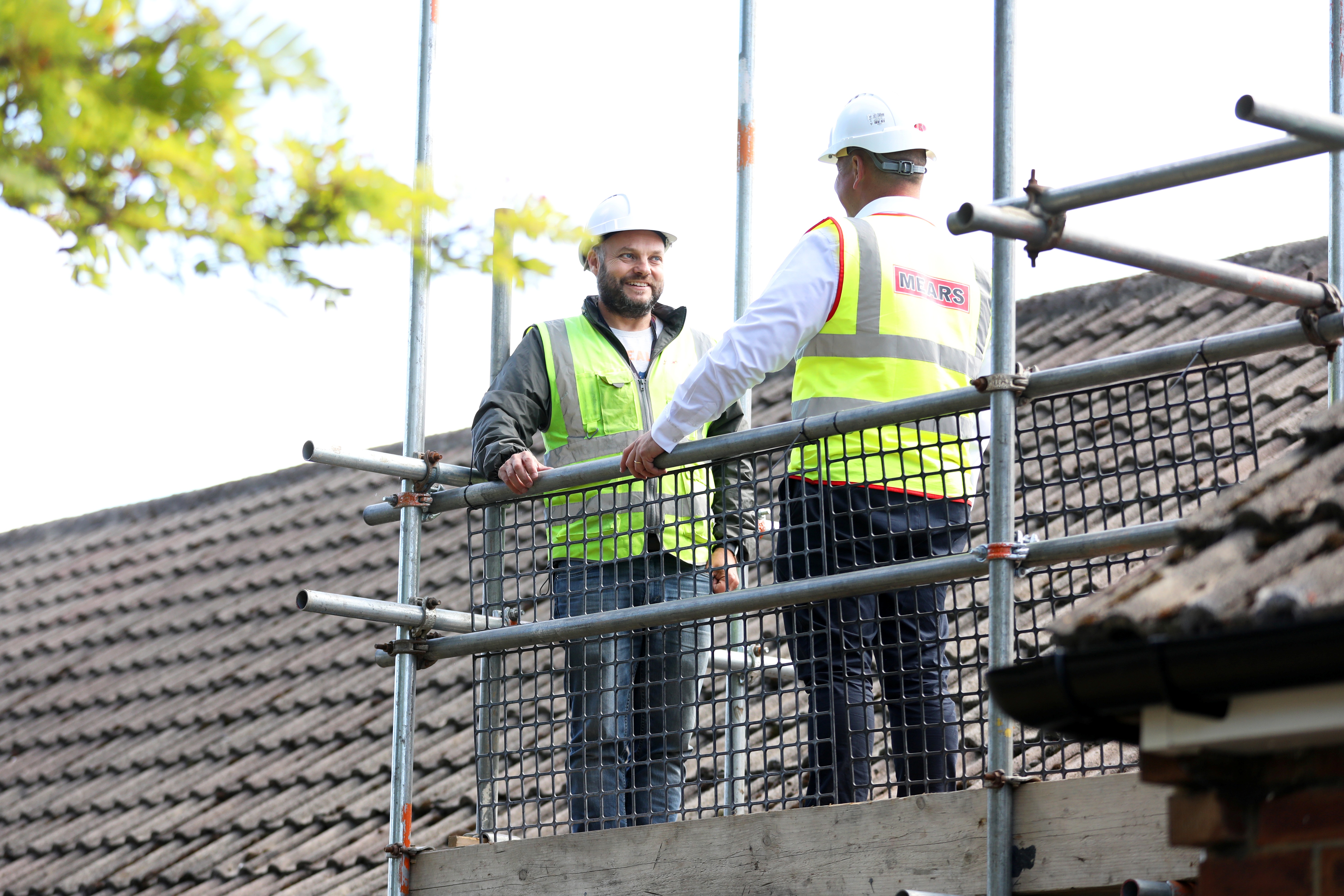 Operatives standing on a scaffold chatting