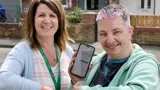 Financial Inclusion Manager and a tenant holding up a phone