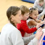 Children and adult drawing on a whiteboard