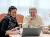 One of our money support advisers chatting with a tenant while smiling at a laptop screen